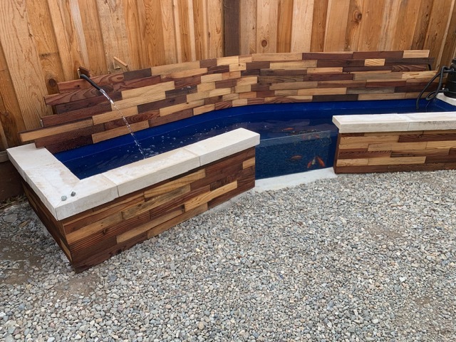 Custom koi pond with wood and stone
